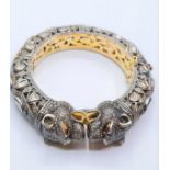 An antique Cartier style yellow and white gold tigers head bangle encrusted with diamonds and