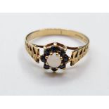 9ct Gold Garnet and Opal Ring. Engine turned design to shoulders. Full UK Hallmark showing 9ct