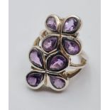 Silver and Amethyst ring having a mount set as two flower heads with eight stones as petals.
