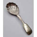 Caddy spoon in white metal. Having a bowl in shell form and a fiddle shaped handle. 11cm approx