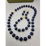 A lapis lazuli and South China Sea pearls necklace, bracelet and earrings set in a presentation box.