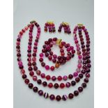 A three row striped red agate necklace, bracelet and earrings set in presentation boxes. Necklace