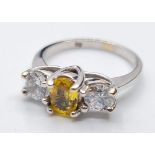 18ct white gold three stone ring. Having a yellow topaz oval centre stone flanked by two large clear