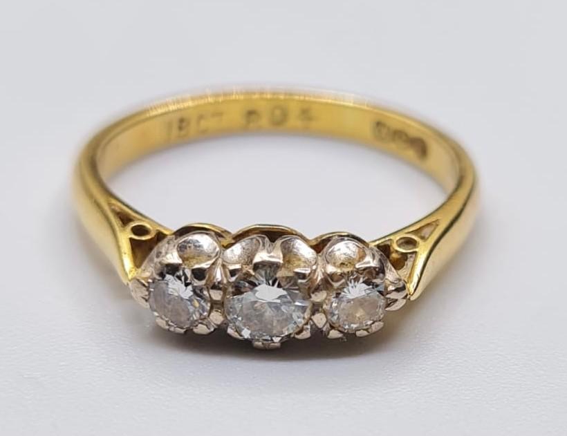 18ct Gold and Diamond Ring. Having three diamonds total. 3 carat with larger stone to centre, Size