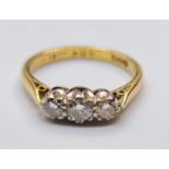 18ct Gold and Diamond Ring. Having three diamonds total. 3 carat with larger stone to centre, Size