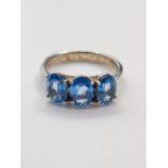 Silver Trilogy ring having three oval stones the colour of blue topaz mounted on a smooth silver