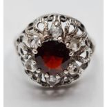 Stone Set Silver Ring having Centre Garnet and 6 Zirconia's Surround Set on a Silver Filigree Mount.