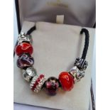 Rhonda Sutton cord charm bracelet. Having silver and glass charms. 9 charms plus clasp. 18.5cm