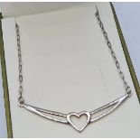 Silver Heart Pendant Attached to a Silver Chain. Pendant Having Pierced Chevron Form with Heart to