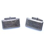 A pair of silver hand engraved cuff links