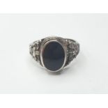 Silver ring having a large black oval onyx stone to top. Intricate gothic silver work to