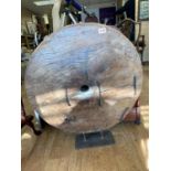 An early oriental solid wooden wagon wheel on stand, 74cm diameter and 80cm tall on stand, very