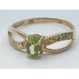 9ct gold ring having faceted oval peridot solitaire to top, pierced shoulders with infinite design