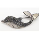 Silver marcasite and mother of pearl dolphin brooch, having a garnet eye with mother of pearl tail