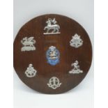 Wooden plaque with Army regimental badges.