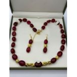 An impressive, large beaded, ruby and gold filled necklace and earrings set in a presentation box.