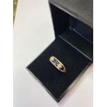 9ct Gold Three Stone Ring having Centre Sapphire with an illusion set diamond to each side.