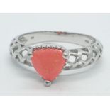 Silver ring having trillion shaped faceted coral stone in silver bead mount, pierced silver work