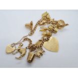 9ct gold vintage charm bracelet with 12 charms weight 53.3gram 18cm long with heart padlock.