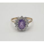 9ct gold ring having oval shaped faceted amethyst to top with clear stone surround, inclusion to