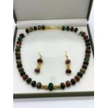 A Chinese multicoloured and multifaceted jade beads with gold filled spacer beads and pixiu dogs