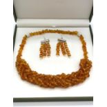 A Baltic amber six row braided necklace and a pair of earrings set in a presentation box. Necklace