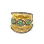 A gold and silver ring with 3 Colombian emeralds and over 150 diamonds (tested) on parallel,