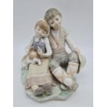 Lladro boy cuddling girl, 17.5cm tall.