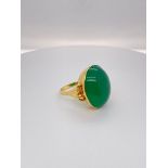 18k yellow gold ring with large oval green emerald cabochon centre (21x17mm), weight 7.64g and