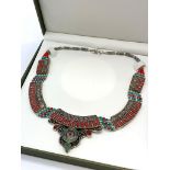 A Tibetan silver with red coral and turquoise ethnic necklace presented in a box. Necklace length: