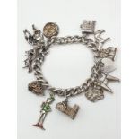 Vintage silver charm bracelet with 12 charms and heart padlock, weight 63.65g and 18cm long approx