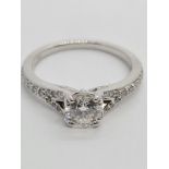 18CT WHITE GOLD ROUND BRILLIANT DIAMOND SOLITAIRE RING WITH DIAMOND SET SPLIT SHOULDERS, 0.60CT