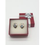 Silver and Topaz blue earrings, having stones to centre with hammered silver surround, boxed