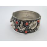 A vintage Italian white metal bangle with cornellean and floral design. 43.5g.