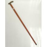 One light mahogany gentleman's walking stick with floral design on antler shaped metal handle.