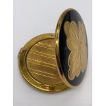 Vintage 1950/60's compact by Melissa. Black enamel lid with gold feature engine turned base.
