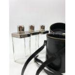 Three glass and chrome hip flasks in leather carrying case.