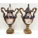 Pair of Grecian style Urns with serpent handles and recoco trim. Very nice condition. Would