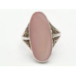 Silver ring having large pink oblong stone to top. Filigree shoulders. Size N and a half / O.