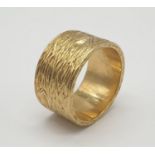 18ct gold wide band ring with grained pattern, weight 14.4g and size O
