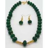 A multifaceted, large beaded, opaque emerald necklace and earrings set in a presentation box.