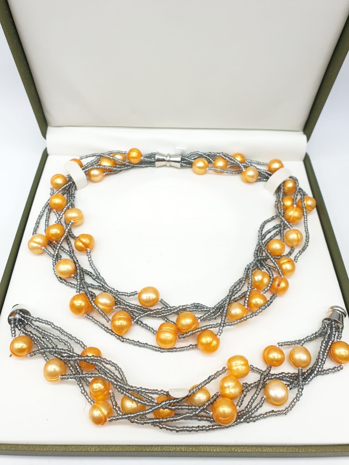 A very unusual necklace and bracelet set with large yellow-orange pearls. In a presentation box.