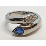 Platinum cross over ring with 0.60ct Thai sapphire and 0.30ct encrusted diamonds, weight 13.7g and