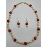 A mother of pearl and red coral necklace and earrings set presented in an unusual Thai, polished,
