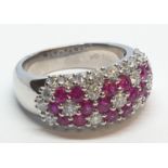 18ct white gold ring with over 1ct ruby and 1.8ct diamonds in flower design, weight 9.39g and size M