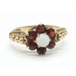 Vintage 9ct gold ring having garnets and opal stones to top in claw mounts. Gold beads to shoulders.