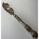 Antique silver butter knife having engraved design to blade and repousse scroll handle, clear