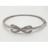 Silver bangle having Zirconia filled infiniti sign to top, presented in purpose made gift box from