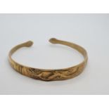 Vintage yellow metal bangle, believed to be oriental with dragon motif. 14.5g.