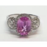 18ct white gold ring with 2.2ct oval pink sapphire centre and 0.50ct brilliant diamond on each